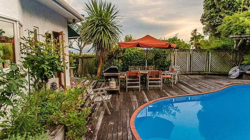 Pool landscape using a wooden lattice fence and vegetation for privacy